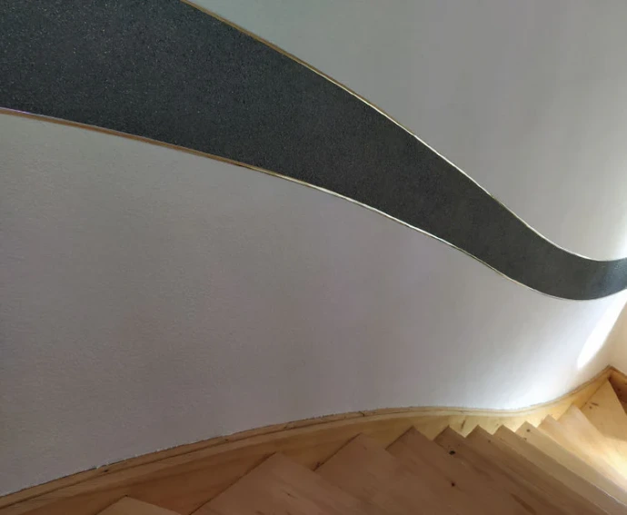 Eine Treppe an der Baumwollputz durch einen wellenförmigen Streifen eines anderen Dekores getrennt wurde